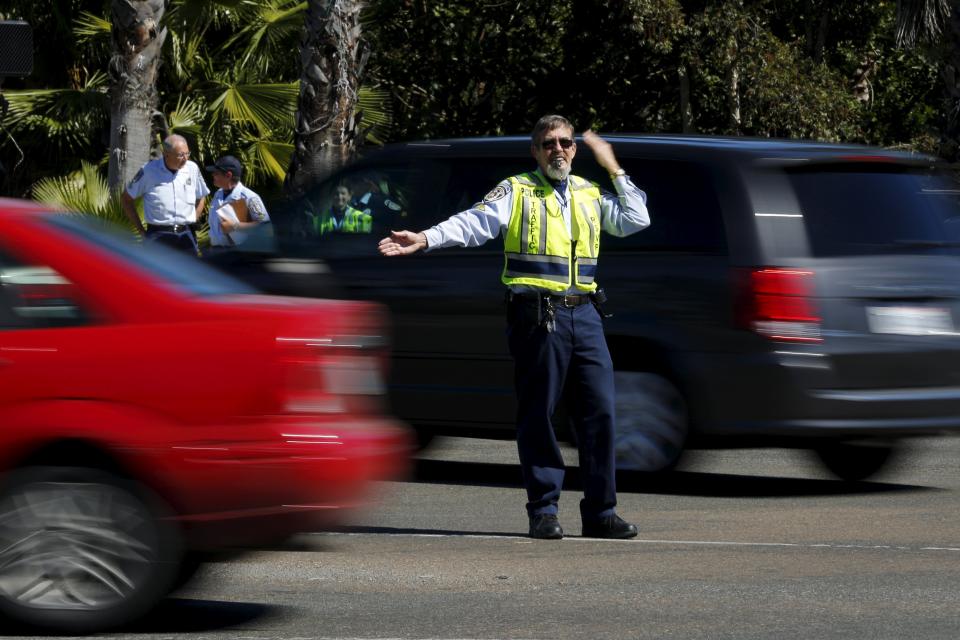 Retired Senior Volunteer Patrol member Dave Netzer is graded for his re-certification for directing traffic as he controls a busy intersection in San Diego, California, United States February 24, 2015. (REUTERS/Mike Blake)