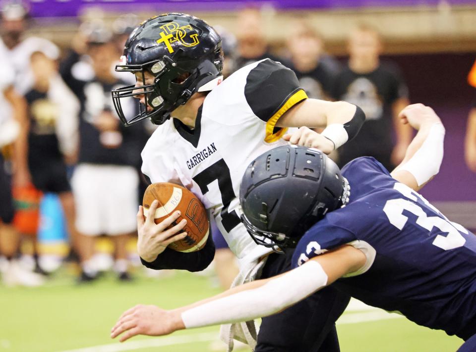 Bishop Garrigan (Algona) sophomore quarterback Tate Foertsch (7) is stopped by Bedford senior Silas Walston (33) in the 8-player championship on Thursday. Foertsch led Bishop Garrigan to the championship with a 39-30 victory.