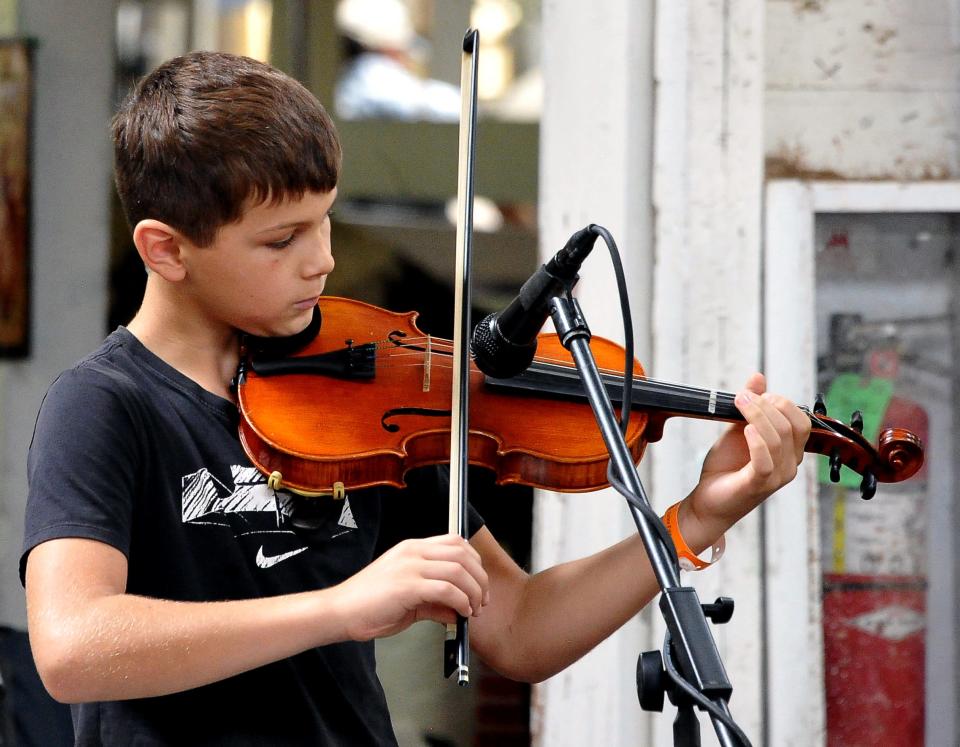 Elliot Wright competes in the 12 and under fiddling contest held in the coliseum at the Wayne County Fair.