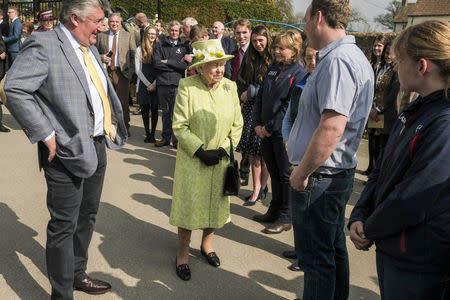 Britain's Queen Elizabeth II greets staff accompanied by trainer Paul Nicholls during a visit to Manor Farm Stables in Ditcheat, Britain March 28, 2019. Matt Keeble/Pool via REUTERS
