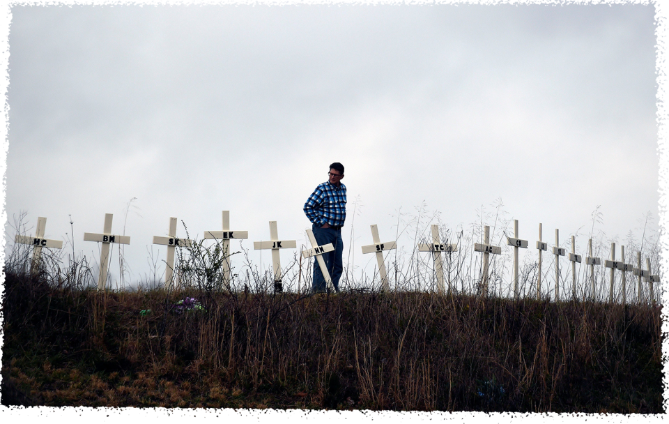 Allen Jingst looks at the 18 crosses erected on a small hill in memory of the victims who died in deadly tornadoes in Cookeville, Tenn.