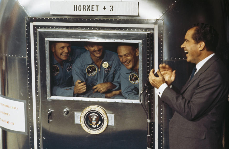 From left to right, Neil Armstrong, Michael Collins and Buzz Aldrin, the crew of the historic Apollo 11 moon landing mission, are subjected to a period of quarantine upon their return to earth. Through the window of their Mobile Quarantine Facility, they hold a conversation with President Richard Nixon. | MPI/Getty Images