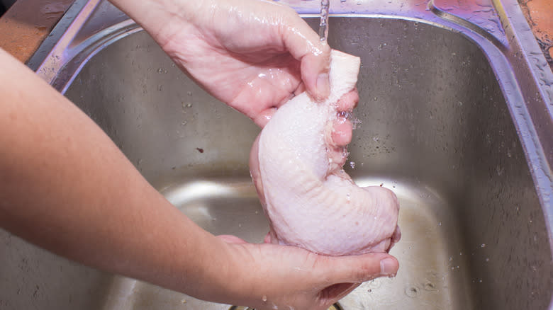 Hands washing chicken