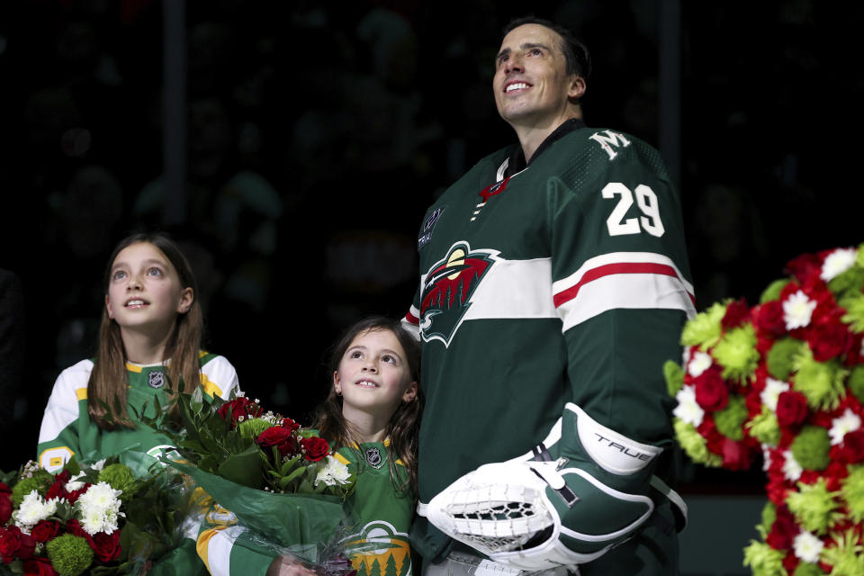 Minnesota Wild goaltender Marc-Andre Fleury (29) and his two daughters, Scarlett and Estelle, watch a video tribute to his more than 1,000 career NHL hockey games, before the team's game against the Pittsburgh Penguins on Friday, Feb. 9, 2024, in St. Paul, Minn. (AP Photo/Matt Krohn)