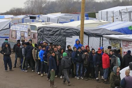 Migrants queue for clothes distribution in southern part of the camp known as the "Jungle", a squalid sprawling camp in Calais, northern France, February 26, 2016. REUTERS/Pascal Rossignol