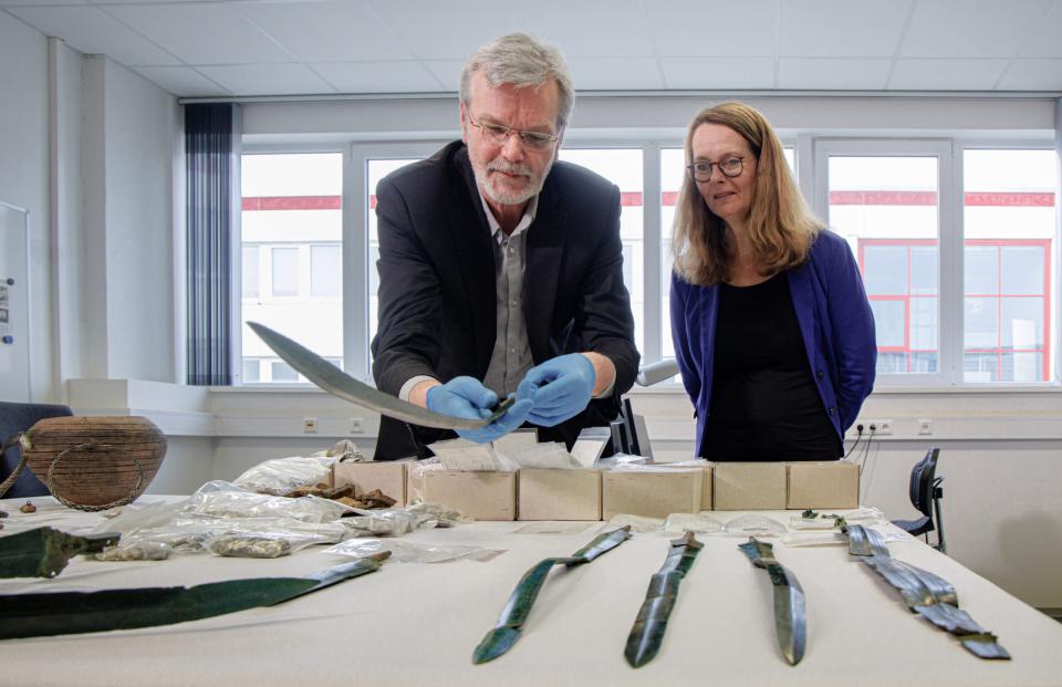 Archäologe Detlef Jantzen und Ministerin Bettina Martin (SPD) betrachten die archäologischen Funde. - Copyright: picture alliance/dpa | Markus Scholz