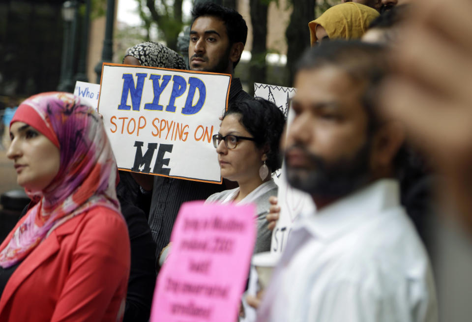 FILE - In this Aug. 28, 2013, file photo, a group of people hold signs protesting the New York Police Department’s program of infiltrating and informing on Muslim communities during a rally near police headquarters in New York. On Tuesday, April 15, 2014, the NYPD confirmed it disbanded the special intelligence unit that monitored Muslim communities in New York and New Jersey. (AP Photo/Seth Wenig, File)