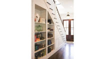 <p>In this home, even often-overlooked areas, like the space under the stairs, have been transformed into storage solutions. Tuck cookbooks and collectibles into these open shelves. </p>