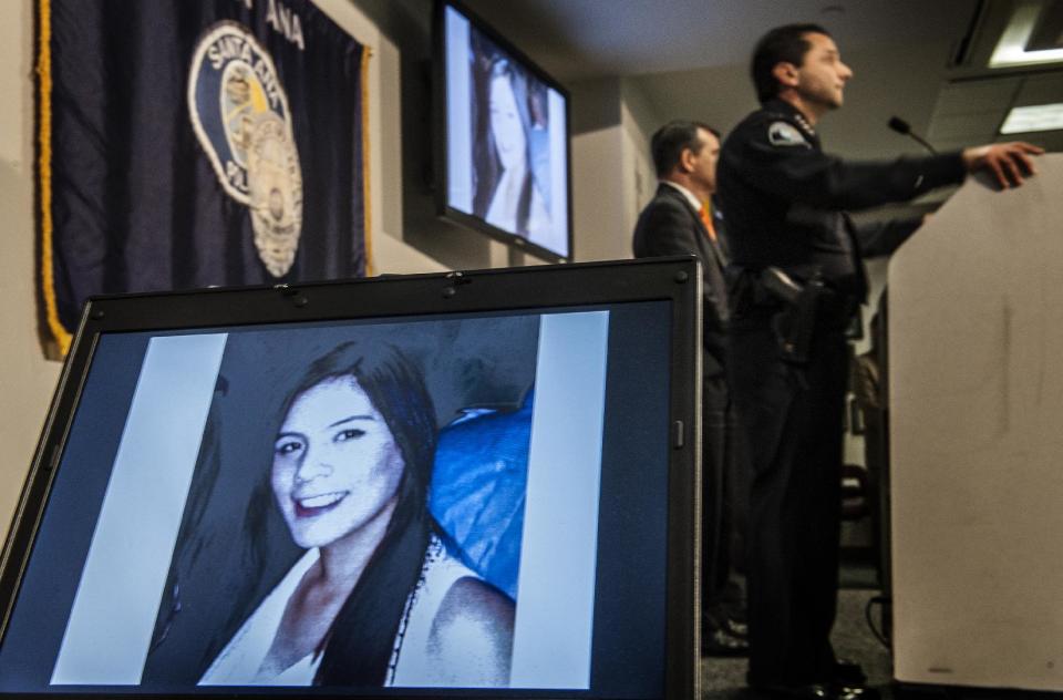 Santa Ana Police Chief Carlos Rojas, top right, holds a news conference to announce that a second suspect had been arrested for investigation of murder in the case of beating victim Annie "Kim" Pham, Friday, Jan. 24, 2014 in Santa Ana, Calif. Two women were arrested and a third "person of interest," shown on screen bottom left, is being sought by police. Police don't know the identity of the third woman but investigators would like to talk to her, the chief said. (AP Photo/The Orange County Register, Bruce Chambers) MAGS OUT; LOS ANGELES TIMES OUT