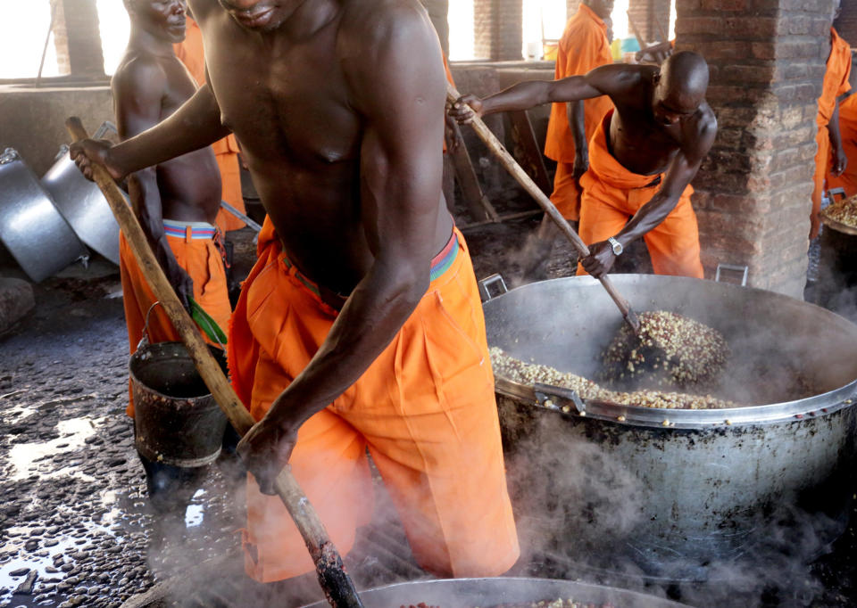 Prisoners cook corn at Rwamagana Prison in Rwamagana, Rwanda, on November 18, 2017. All of Rwanda's prisons use their prisoners' waste - in addition to that of cows - to fuel their kitchens via biogas. At Rwamagana, biogas is used to cook corn, and peat cooks rice and beans. Many prisoners say they can usually tell when biogas is used due to the lack of smokey flavor in food. (Photograph by Yana Paskova)