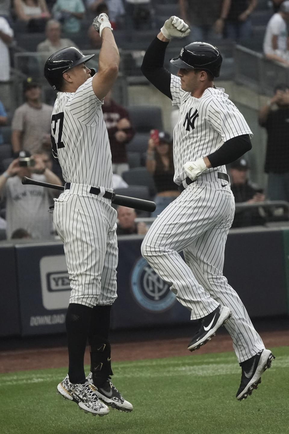 New York Yankees' Anthony Rizzo, right, bumps fists with teammate Giancarlo Stanton after his home run during the first inning of a baseball game against the Oakland Athletics, Monday, June 27, 2022, in New York. (AP Photo/Bebeto Matthews)