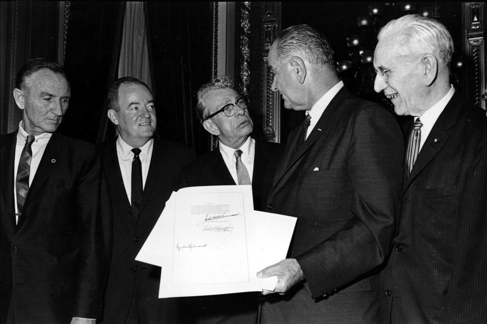 FILE - President Lyndon B. Johnson holds the signed document of the Voting Rights Act of 1965 as he talks with Sen. Everett Dirksen, R-Ill., in the President's Room at the U.S. Capitol in Washington, on Aug. 6, 1965, as House Speaker John McCormack, right, Vice President Hubert Humphrey, second from left, and Sen. Mike Mansfield listen. Lucy Baines Johnson said in a recent interview personal relationships and events in her father's life influenced his thinking on civil rights and voting rights, as well as many of the social programs he helped established. (AP Photo)