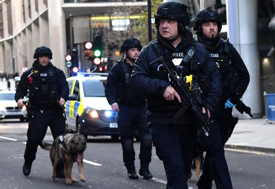 Armed police with dogs patrol along Cannon Street in central London, on Nov. 29, 2019.