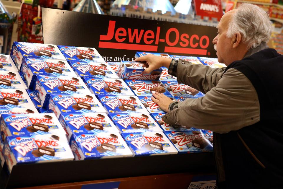 An elderly male shopper takes a box of Hostess Zingers cakes from a display of the company's snacks at a Jewel-Osco store in Chicago.