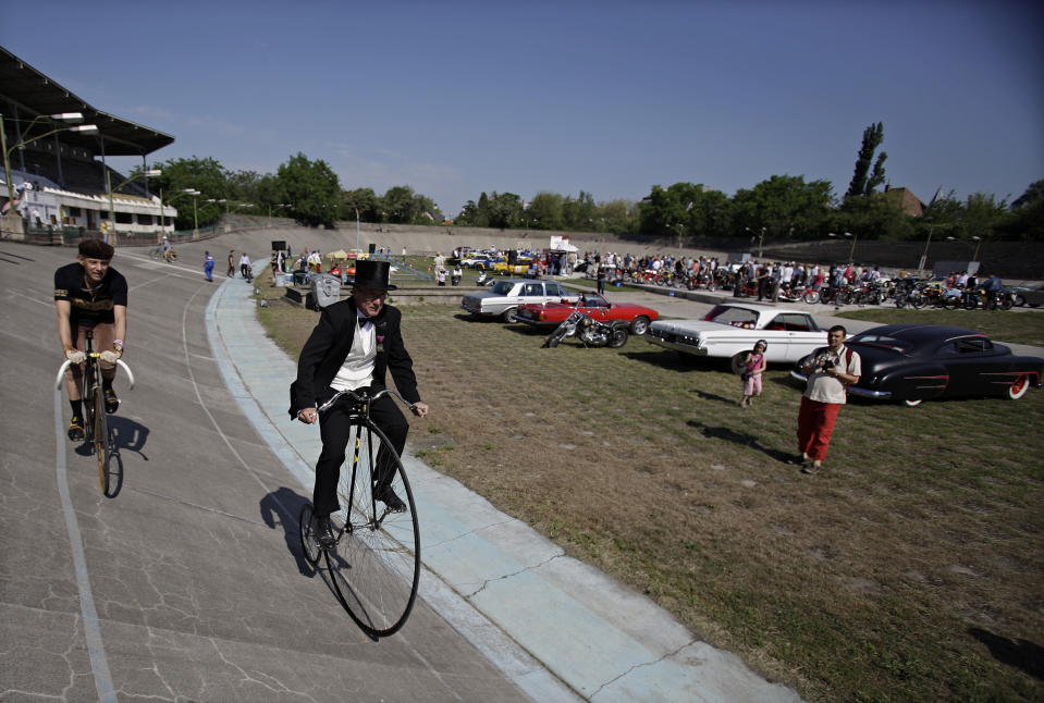 Men ride bicycles on an oval track of a velodrome during an old timer car and motorcycle show in Budapest on May 1, 2012. The event brought life again into the 412 meter long Millennial Velodrome of Budapest, which was built in 1896 and is one of the oldest arenas for track cycling in Europe.  AFP PHOTO / PETER KOHALMIPETER KOHALMI/AFP/GettyImages