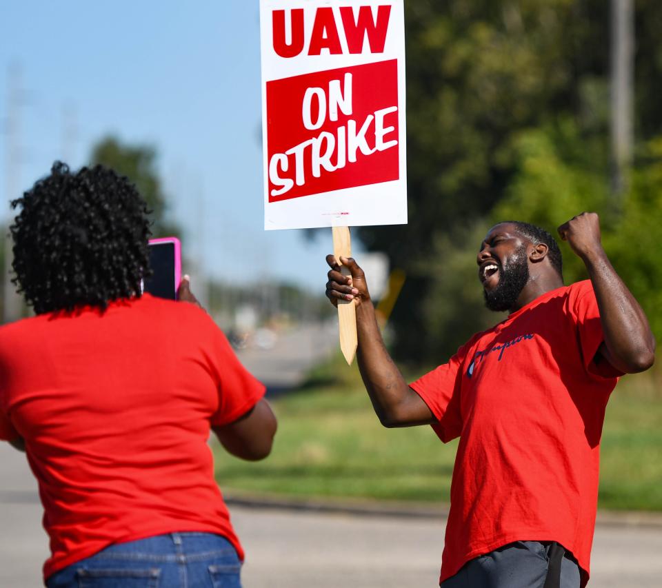 Jacquline Brent takes a picture Wednesday of fellow UAW member Porter Williams while picketing near the GM Lansing Delta Township plant. Brent has worked at GM for 31 years, and Williams for three.