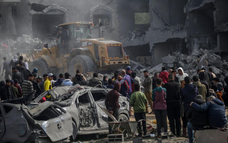 Palestinians search for bodies and survivors among the rubble of a destroyed house following an Israeli air strike on Deir Al Balah, southern Gaza Strip
