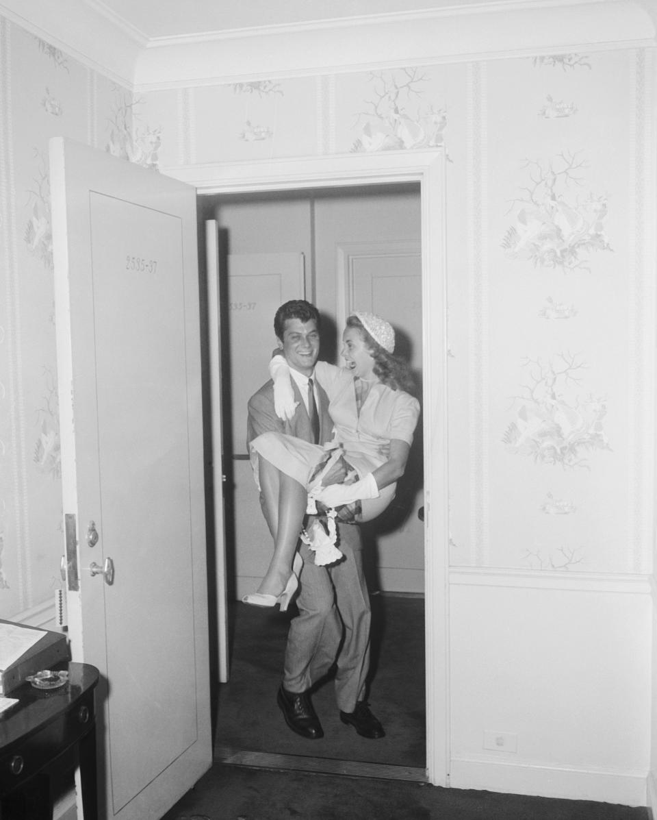 <p>Tony Curtis carries his new wife, Janet Leigh into their honeymoon suite at the Waldorf Astoria in New York City.</p>