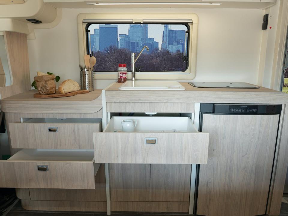 The Oasi 540's kitchen with bread on the counter and several drawers open