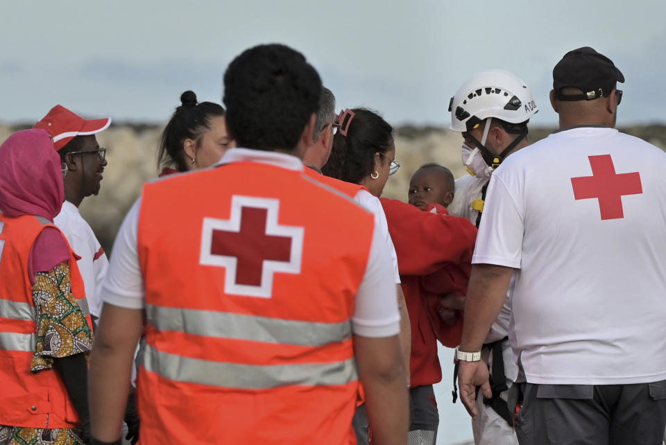 Miembros de la Cruz Roja cargan un bebé en el puerto de La Restinga, en El Hierro, en las Islas Canarias, el sábado 6 de junio de 2024, tras ser rescatado por la agencia española Salvamento Marítimo. Las Islas Canarias están teniendo problemas para atender a los miles de niños y adolescentes que viajan solos al archipiélago español desde Senegal, Mali y otras naciones africanas. (Europa Press via AP)