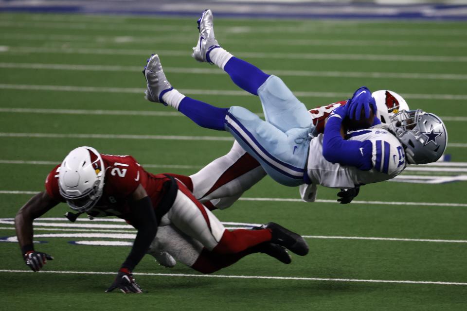 Arizona Cardinals cornerback Patrick Peterson (21) and linebacker Jordan Hicks, rear, combine to tackle Dallas Cowboys running back Ezekiel Elliott, right front, after a short gain in the second half of an NFL football game in Arlington, Texas, Monday, Oct. 19, 2020. (AP Photo/Ron Jenkins)