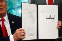 U.S. President Donald Trump displays an executive order on immigration policy after signing it in the Oval Office at the White House in Washington, U.S., June 20, 2018. REUTERS/Leah Millis