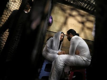 Aya Hijazi and her husband Mohamed Hassanein, founders of a non-governmental organisation that looks after street children, talk inside a holding cell as they face trial on charges of human trafficking, sexual exploitation of minors, and using children in protests, at a courthouse in Cairo, Egypt March 23, 2017. REUTERS/Mohamed Abd El Ghany