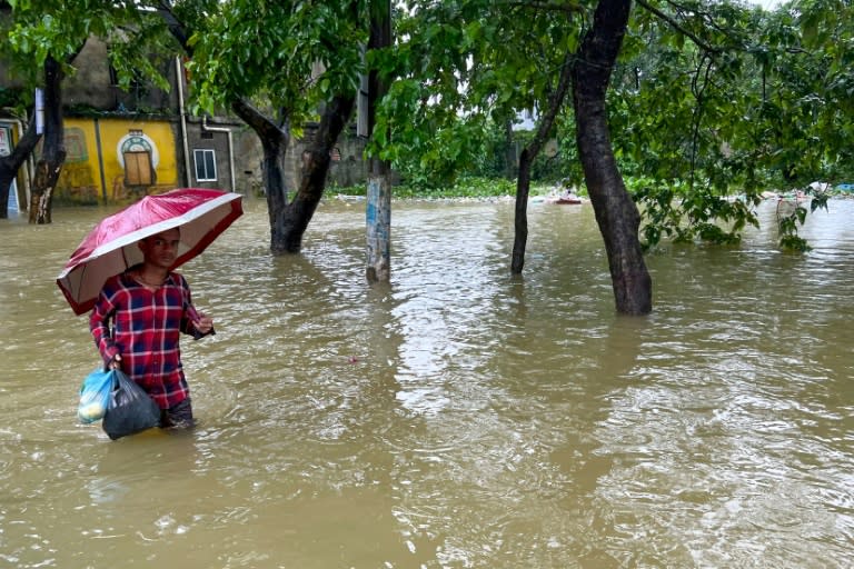 Un hombre vadea una zona inundada en Sylhet (Bangladesh) el 19 de junio de 2024 (-)