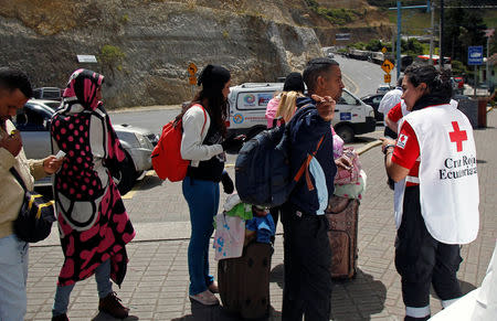 Venezuelan migrants ask members of the Red Cross for assistance after going through Ecuadorean migration, at the Rumichaca International Bridge, Ecuador August 9, 2018. Picture taken August 9, 2018. REUTERS/Daniel Tapia