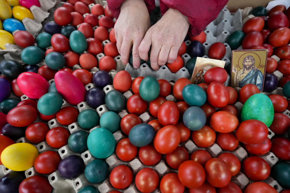 A vendor arranges hand-decorated Easter eggs, on Orthodox Good Friday at a green market, in Belgrade, Serbia, Friday, April 14, 2023. Orthodox Serbs celebrate Easter on April 16, according to the old Julian calendar. (AP Photo/Darko Vojinovic)