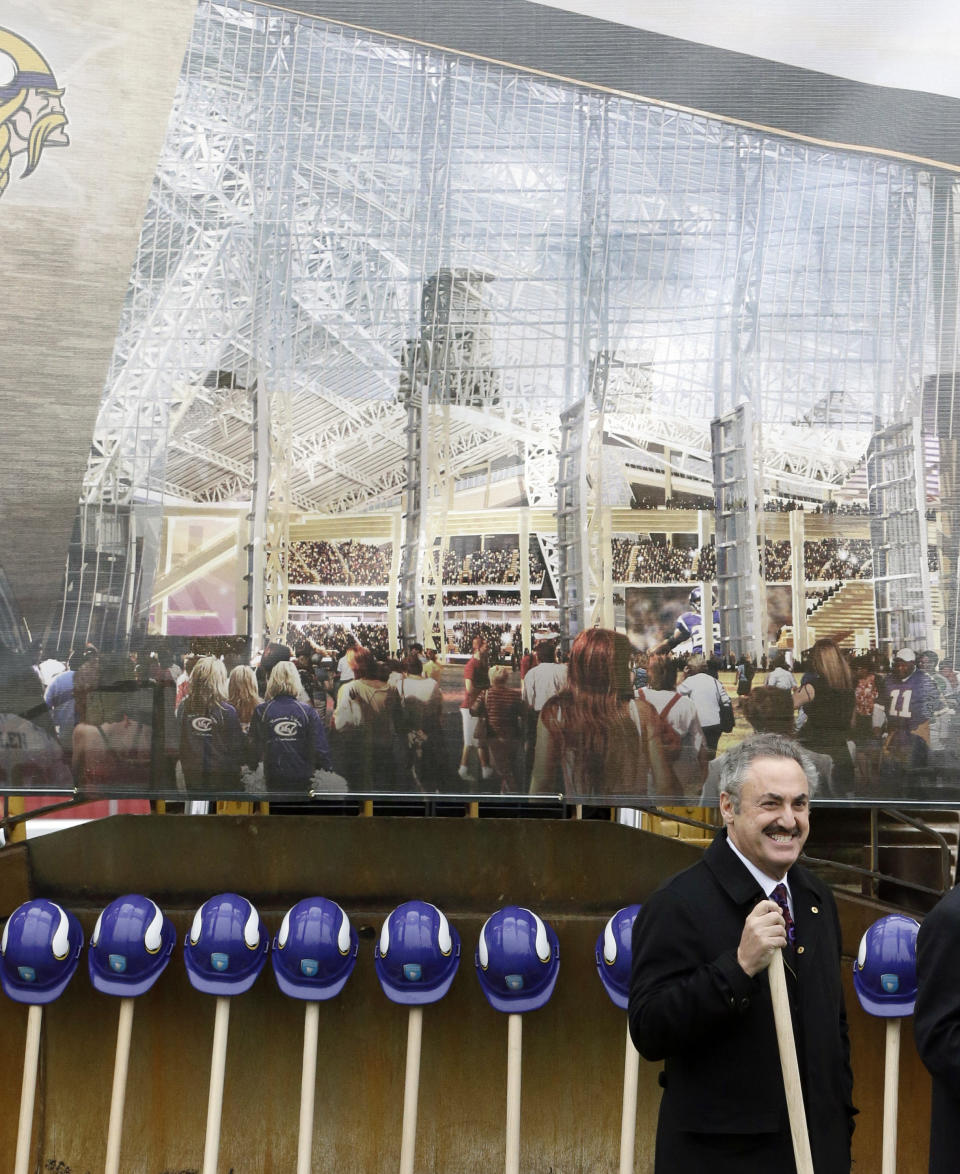 FILE - In this Dec. 3, 2013, file photo, a large rendering of the new Minnesota Vikings stadium hangs behind Vikings owner Zygi Wilf, right, as he waits to shovel the first dirt during one of several ceremonial dirt tosses at a groundbreaking ceremony for the Vikings newNFL football stadium in Minneapolis. Minnesota's Supreme Court on Tuesday, Jan. 21, 2014, dismissed a lawsuit challenging the funding plan for a new Vikings football stadium, eliminating a legal obstacle that threatened a last-minute derailment of the project. The lawsuit was filed Jan. 10 by Doug Mann, an activist and former Minneapolis mayoral candidate who argued the stadium funding plan was unconstitutional. The state's highest court disagreed. (AP Photo/Jim Mone)