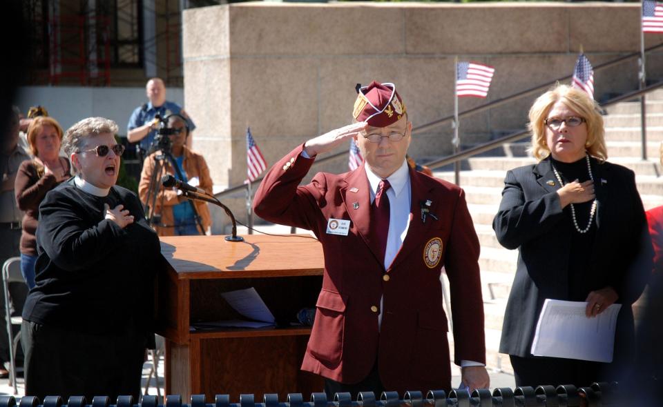 Former prisoner of war David Drummond (center) salutes during a ceremony on National POW/MIA Recognition Day.