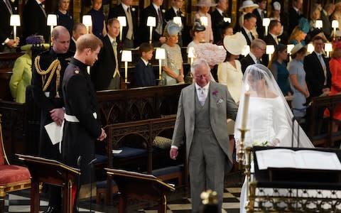 Prince Harry looks at his bride, Meghan Markle, as she arrives accompanied by the Prince of Wales in St George's Chapel  - Credit: Jonathan Brady/PA