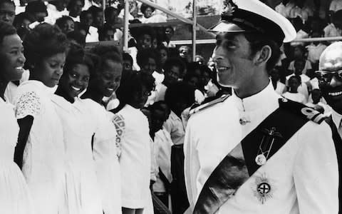 Prince Charles wearing naval uniform as he greets a group of choir girls, during the opening of the Prince of Wales Bastion in St Kitts, 1973 - Credit: Fox Photos/Hulton Archive/Getty Images