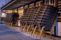 Chairs are piled up outside a restaurant in Haffkrug at the Baltic Sea, Germany, Monday, Jan. 4, 2021. To avoid the outspread of the new coronavirus all restaurants in Germany are closed. (AP Photo/Michael Probst)