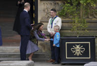 El príncipe Guillermo de Inglaterra y su esposa Kate, la duquesa de Cambridge, hablan con Archie McWilliams, de 7 años, del First Longford Scout Group en Stretford, y su tío, el comisionado del condado de Greater Manchester West Scouts, Andy Farrell, al salir de la inauguración del monumento Glade of Light afuera de la Catedral de Manchester, en memoria de las víctimas de un ataque suicida en un concierto de 2017 de Ariana Grande, el martes 10 de mayo de 2022 en Manchester, Inglaterra. (Foto AP/Jon Super)