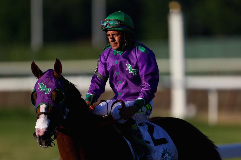 California Chrome #2, ridden by Victor Espinoza, walks down the track after losing the 146th running of the Belmont Stakes at Belmont Park on June 7, 2014 in Elmont, New York