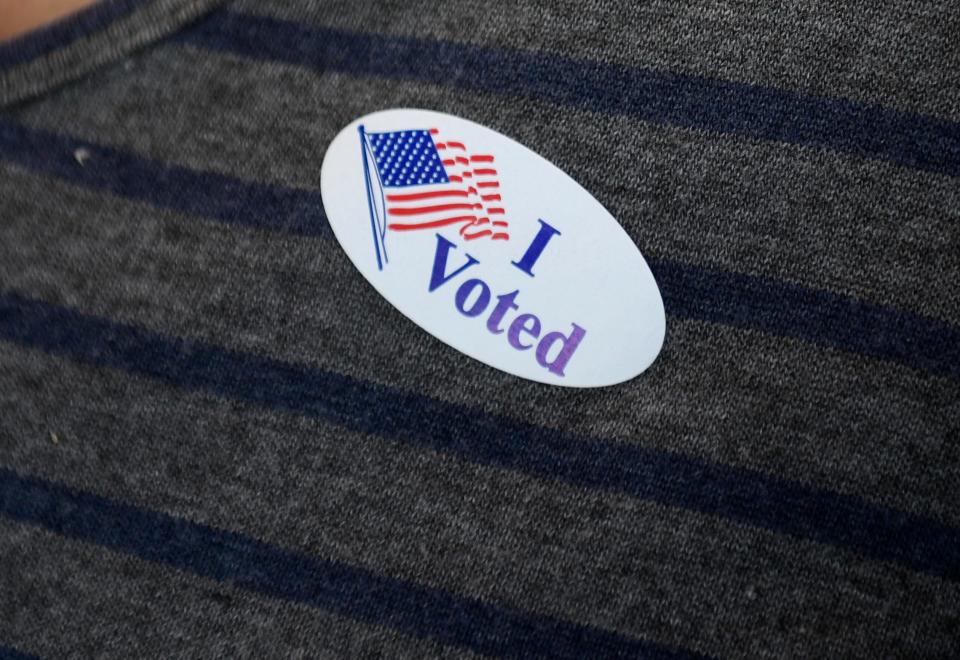A woman wears an "I voted" sticker during Election Day, Tuesday, Nov. 2, 2021, at the Deaf and Hard of Hearing Center polling location.