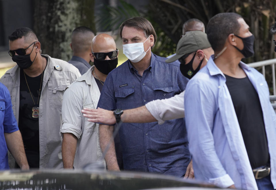 Surrounded by federal police officers, Brazil's President Jair Bolsonaro, center, leaves a polling station after voting in municipal elections in Rio de Janeiro, Brazil, Sunday, Nov. 15, 2020. (AP Photo/Ricardo Borges)