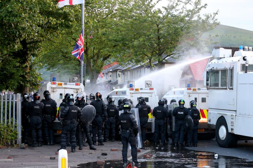 Police dealing with violence in North Belfast on July 13, 2015 with a large group of riot police visible and water canon deployed