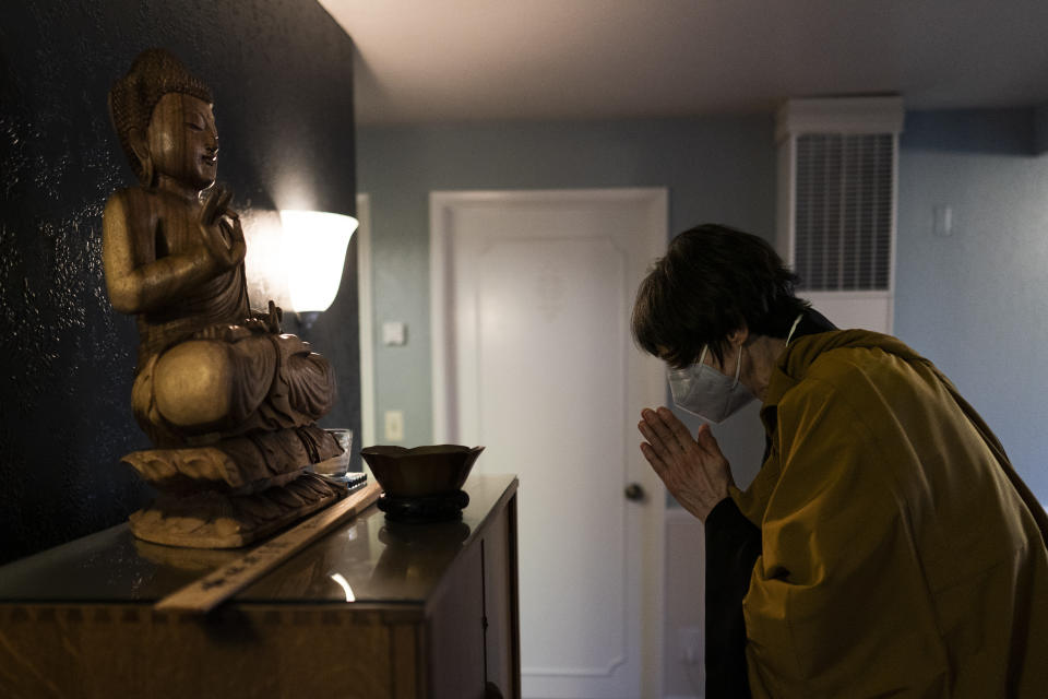 Resident priest Genmyo Jana Zeedyk bows before a Buddha statue during a Sunday practice at the Anchorage Zen Community in Anchorage, Alaska, Sunday, Oct. 9, 2022. The Anchorage Zen Community is influenced by the northernmost state's seasonal rhythms that include long, dark winters as well as short summers when the sun only dips below the horizon for brief stretches, said Zeedyk, who has been the resident priest for more than a decade. (AP Photo/Jae C. Hong)