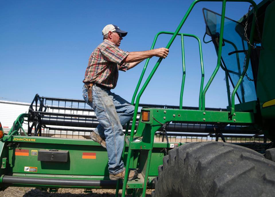 Randy Miller climbs into his John Deere combine to harvest one of his soybean fields on Friday, Oct. 8, 2021.