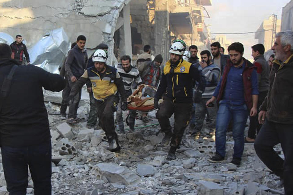 This photo released by the opposition Syrian Civil Defense rescue group, also known as White Helmets, which has been authenticated based on its contents and other AP reporting, shows Civil Defense workers evacuate a victim from site of airstrikes in the village of Balyoun, in Idlib province, Syria, Saturday, Dec. 7, 2019. Airstrikes on areas in the last major rebel stronghold in northwest Syria on Saturday killed at least 18 people, including women and children, and wounded others as a three-month truce crumbles, opposition activists said. (Syrian Civil Defense White Helmets via AP)