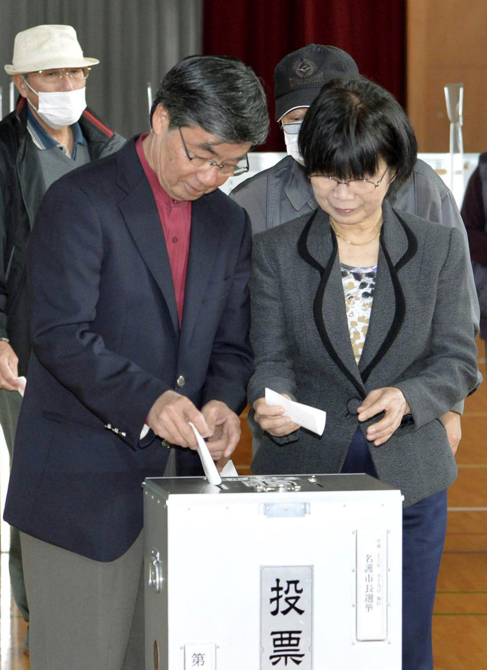 Nago city Mayor Susumu Inamine and his wife Ritsuko cast their ballots in the mayoral election in Nago, on the southern Japanese island of Okinawa, Sunday, Jan. 19, 2014. The small-town mayoral election is being closely watched from Washington to Tokyo as a referendum on long-delayed plans to move a U.S. air base to the community of 62,000 people. Inamine, who opposes the move, faces pro-relocation candidate Bunshin Suematsu in the election. (AP Photo/Kyodo News) JAPAN OUT, CREDIT MANDATORY