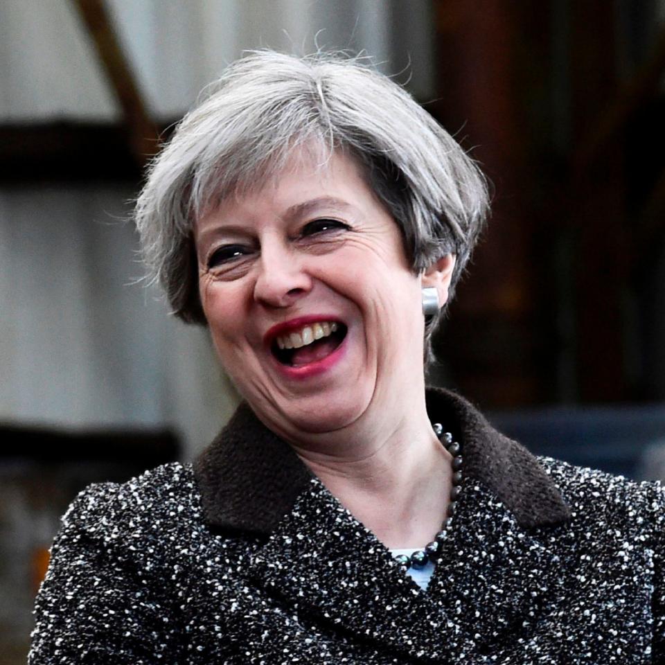 Theresa May laughing  - Credit: AFP