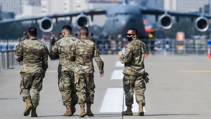 US military personnel walking on the tarmac