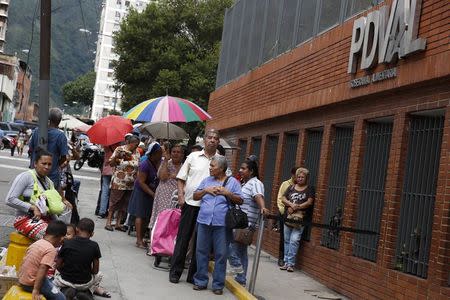 People stand in line to buy food outside a state-run supermarket in Caracas November 14, 2014. Picture taken November 14. REUTERS/Carlos Garcia Rawlins