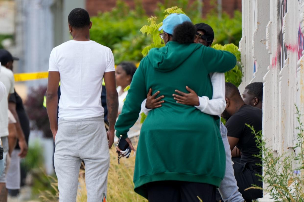 Mourners gather outside of the scene of a suspected homicide at 1748 Queen City Ave. in the South Fairmount neighborhood of Cincinnati on Monday.