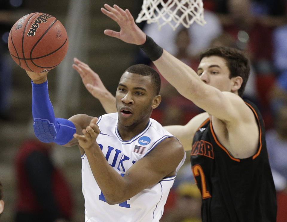 Duke guard Rasheed Sulaimon (14) passes a rebounded ball against Mercer forward Daniel Coursey (52) during the first half of an NCAA college basketball second-round game, Friday, March 21, 2014, in Raleigh, N.C. (AP Photo/Chuck Burton)