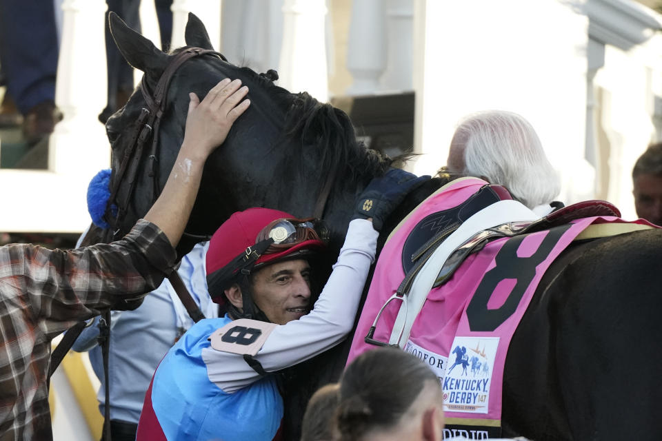 Jockey John Velazquez hugs Medina Spirit in the winner's circle after winning the 147th running of the Kentucky Derby at Churchill Downs, Saturday, May 1, 2021, in Louisville, Ky. (AP Photo/Jeff Roberson)